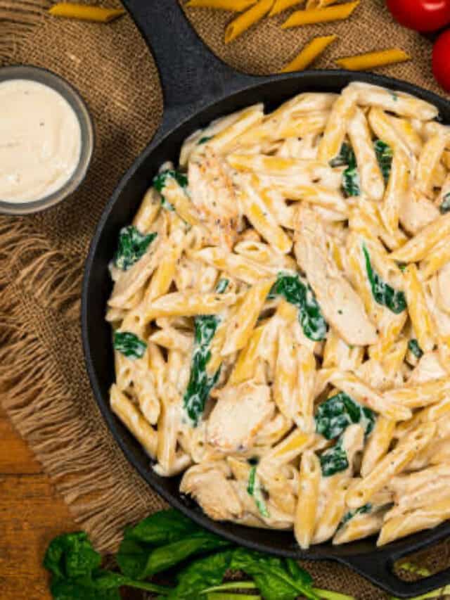 A steaming bowl of restaurant-style white sauce pasta garnished with herbs.